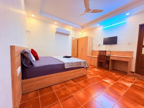 ein Schlafzimmer mit einem Bett und einem Schreibtisch mit einem Computer in der Unterkunft Athirappilly Heritage Villa - 2BHK -River Side in Athirappilly