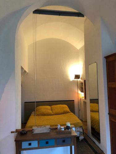 une chambre avec un lit et un miroir dans l'établissement studio au coeur de Lacoste, à Lacoste
