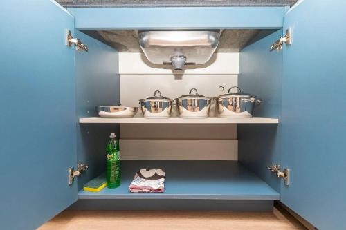 a blue kitchen with four pots and a sink at Vibe Curitiba by Housi, próximo à Ligga Arena e Praça do Japão in Curitiba