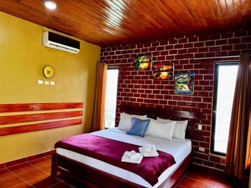 a bedroom with a bed with a brick wall at Saraya Lodge & Camping in Iquitos