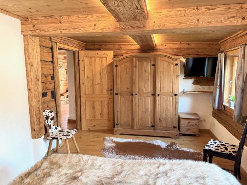 a bedroom with wooden cabinets and a television in a room at CHALET BELLE WILD by Belle Stay in Going