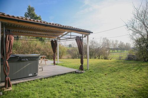 a wooden deck with a gazebo in a field at Home with HotTub near AltonTowers & Waterworld sot in Stoke on Trent