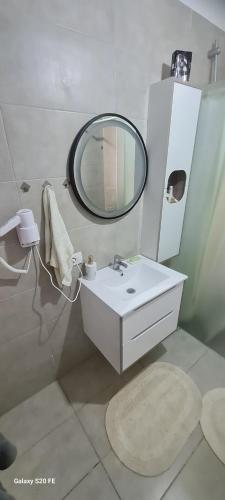 a bathroom with a white sink and a mirror at Villa Buki in Lezhë
