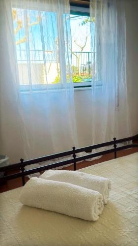a bed with two towels on it with a window at House Mariona in Caminha