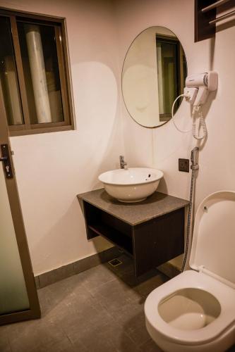 a bathroom with a sink and a toilet and a mirror at Nirili Villa in Dhiffushi