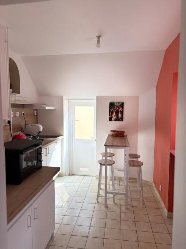 - une cuisine avec un comptoir et des tabourets dans l'établissement Appartement cosy en plein coeur de Montargis, à Montargis