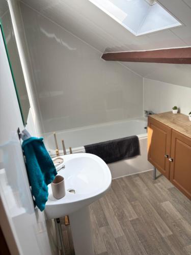 ein Badezimmer mit einem weißen Waschbecken und einem blauen Handtuch in der Unterkunft Appartement cosy en plein coeur de Montargis in Montargis