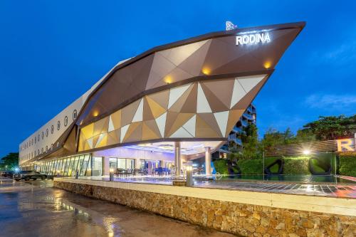 a building with a geometric roof at night at Rodina Beach Hotel in Jomtien Beach