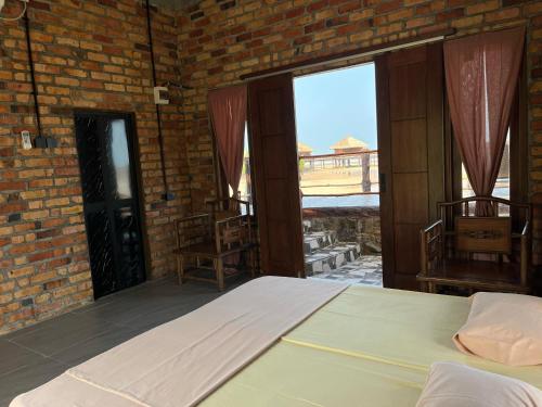a bedroom with a bed and a brick wall at LooLa Adventure Resort in Telukbakau