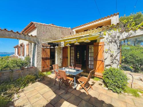 un patio avec une table et des chaises devant une maison dans l'établissement Maison Domaine privé de Port d 'Alon, aux Lecques