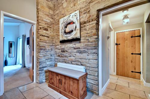 a hallway with a stone wall and a bench at Finest Retreats - Stable Cottage in Bellerby