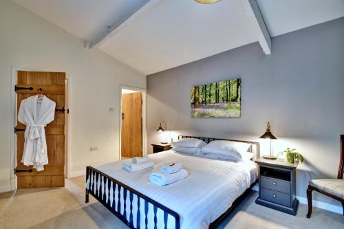 a bedroom with a large bed with towels on it at Finest Retreats - Stable Cottage in Bellerby