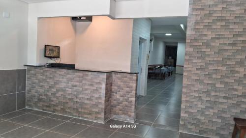 a lobby with a brick wall and a tile floor at Hotel Santa Catarina in Santos