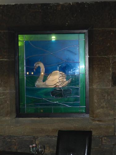 a stained glass window of a swan in the water at White Swan Inn in Belford