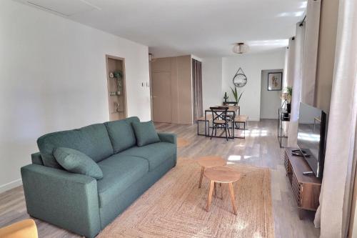 un salon avec un canapé bleu et une table dans l'établissement Chez Nel, à Figeac