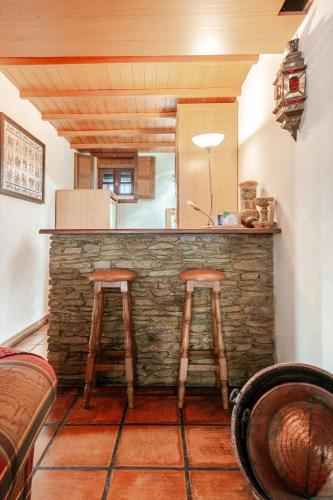 a kitchen with a bar with two stools at Casa dos Araújos in Mirandela