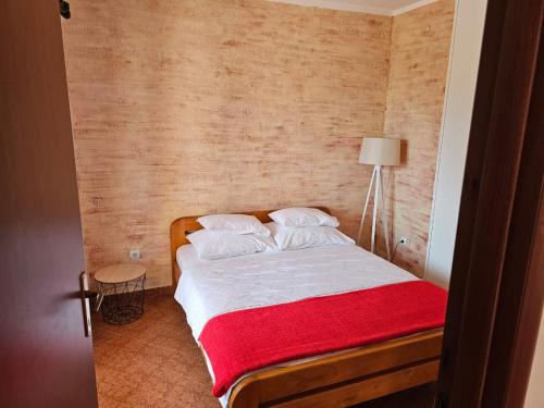 a bedroom with a bed with a red blanket at Vila Marina in Buljarica