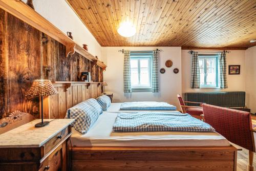 a bedroom with a bed and a desk and windows at SIEGLGUT in Altaussee
