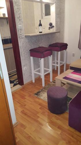 a living room with two purple stools and a counter at Vila Marina in Buljarica