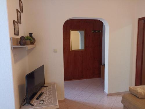 a living room with a television and a door at Vila Marina in Buljarica