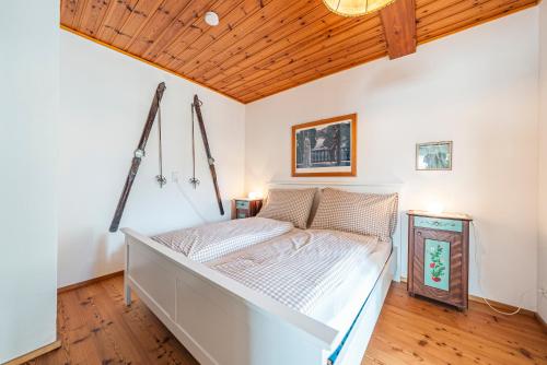 a bed in a room with a wooden ceiling at SIEGLGUT in Altaussee