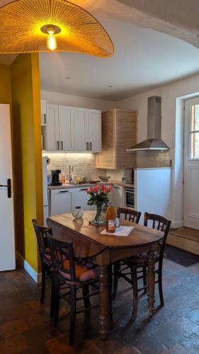une cuisine avec une table en bois et des chaises ainsi qu'une salle à manger dans l'établissement Hameau des Galottières-Perche, immersion nature, à Ceton