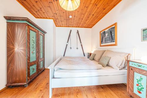a bed in a room with a wooden ceiling at SIEGLGUT in Altaussee