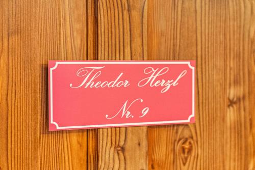 a pink sign on a wooden wall at SIEGLGUT in Altaussee