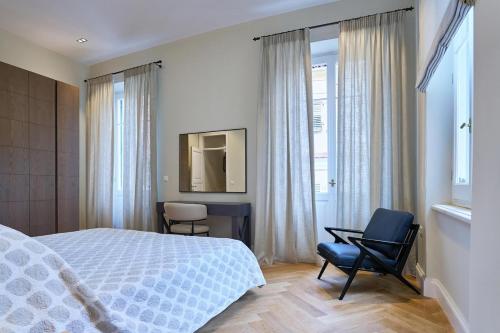 a bedroom with a bed and a chair and a window at Apartments Garitsa 2 in Agios Rokkos