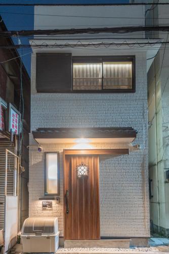 a brick building with a wooden door and a window at 楽逸グループSkytree 105T in Tokyo