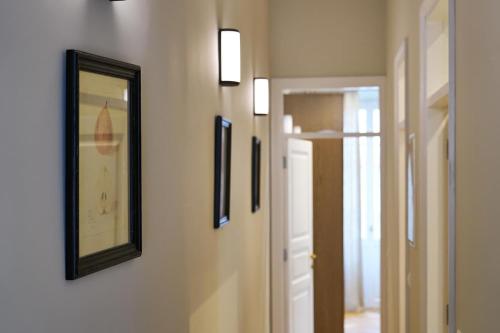 a hallway with pictures on the wall and a mirror at Apartments Garitsa 2 in Agios Rokkos