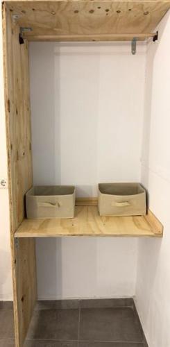 two boxes sitting on a wooden shelf in a wall at Peters Studio in Archangelos