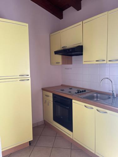a kitchen with yellow cabinets and a sink at Hotel Villa Costanza in Pontenure