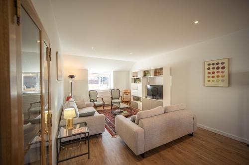 a living room with two couches and a table at Gîte et studio Les Grands Crus in Morey-Saint-Denis