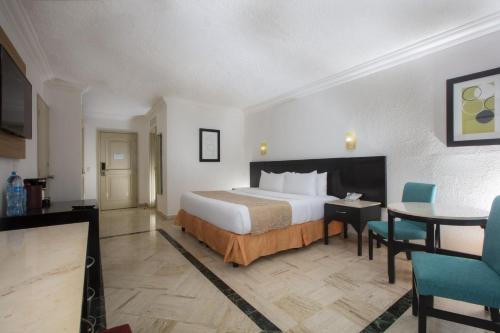a large hotel room with a bed and a table at Krystal Cancun in Cancún