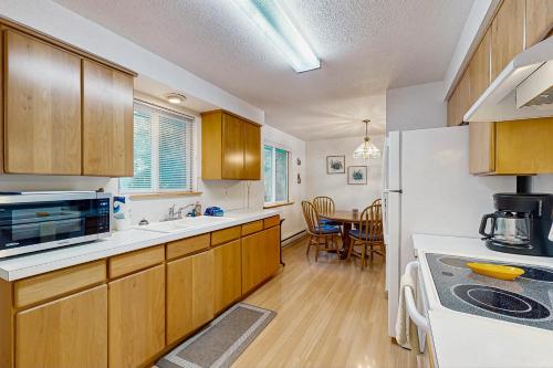 a kitchen with wooden cabinets and a dining room at Cottage on Hemlock Street in Cannon Beach