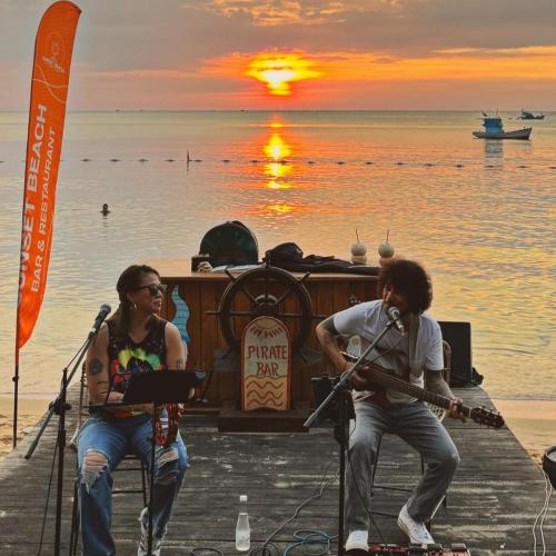 a group of people playing music on the beach at sunset at Sunset Beach Resort and Spa in Phu Quoc