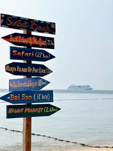 a street sign on the beach with a cruise ship in the background at Sunset Beach Resort and Spa in Phu Quoc
