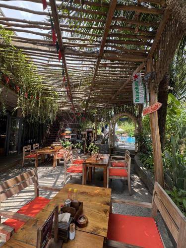 a restaurant with tables and chairs and a pergola at Sunset Beach Resort and Spa in Phu Quoc
