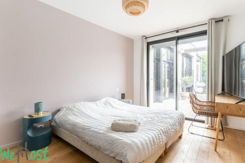 - une chambre blanche avec un lit et une porte coulissante en verre dans l'établissement Architect's house - unique services - 8p, à Nantes