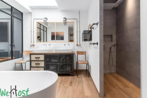 une salle de bain avec une baignoire, un lavabo et un miroir dans l'établissement Architect's house - unique services - 8p, à Nantes