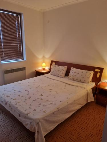 a bedroom with a large bed with two pillows at Ski & View Pamporovo Apartment in Smolyan