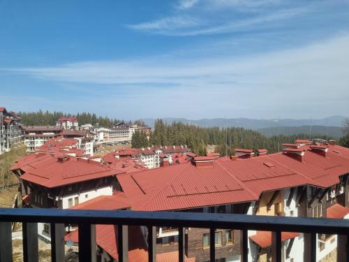 a view of a city from a balcony with red roofs at Ski & View Pamporovo Apartment in Smolyan