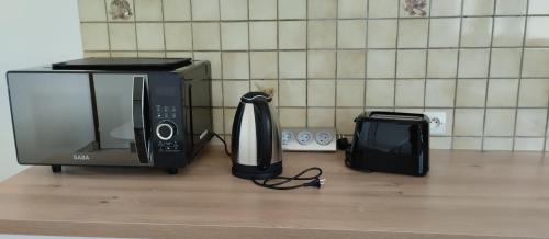a microwave and a toaster oven on a kitchen counter at Au fief du château in Airvault