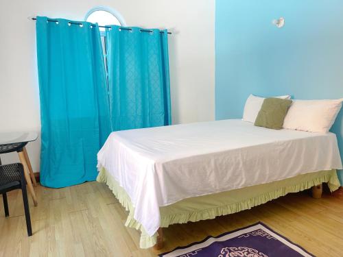 a bed with blue curtains in a room at Skyline Suites Villa and Spa in Montego Bay