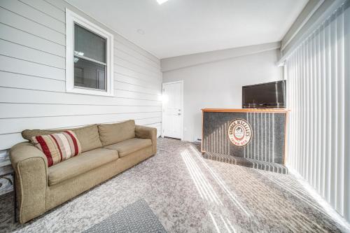 a living room with a couch and a flat screen tv at Walk to Lake Erie and Beach Access Home with Deck! in Erie