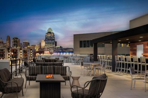 a rooftop patio with tables and chairs and a city skyline at Homewood Suites By Hilton Newport Cincinnati in Newport