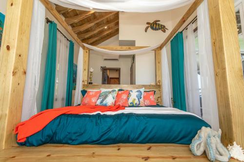 a bedroom with a bed in a room with green curtains at Dakota Breeze - New luxury, oceanfront home with pool!! in Juticalpa