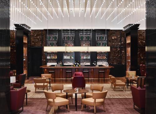 a bar in a restaurant with tables and chairs at Park Hyatt London River Thames in London