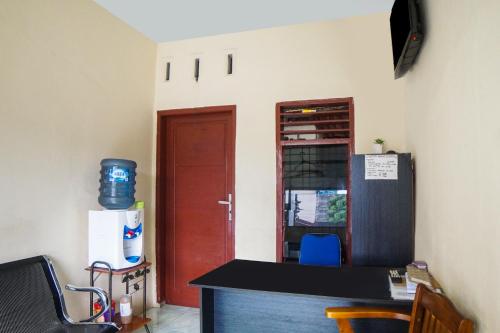 a room with a desk and a door and a refrigerator at Hotel O Sky Residence Cengkeh in Medan